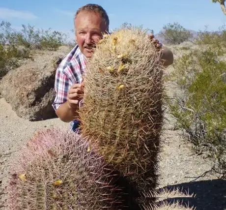 Hans Graf steht hinter drei großen Kakteen